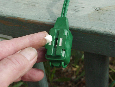 A dab of Dielectric grease closed the unused christmas light sockets